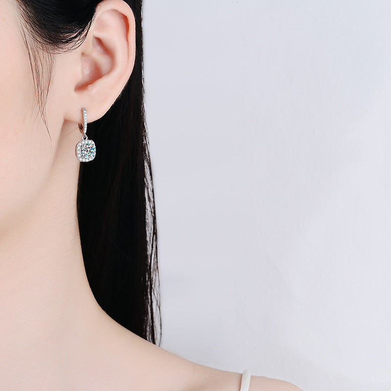 Model wearing the 925 silver inlaid square moissanite pendant earrings, illustrating their elegance and stunning appearance in a casual setting.