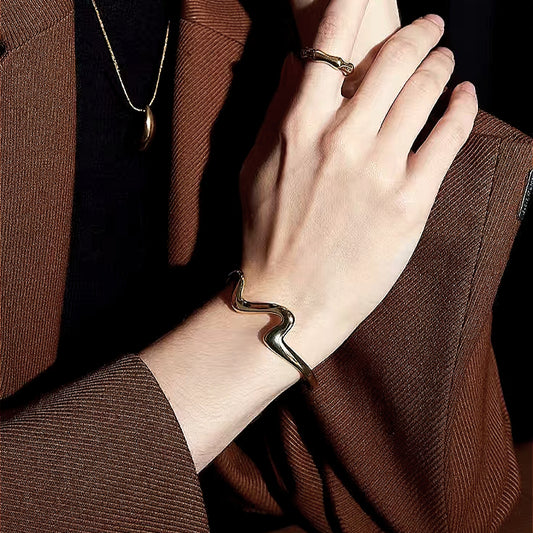  The 925 Silver Plated Gold Wave Opening Bracelet worn on a wrist, illustrating its fashionable appeal and versatile style.
