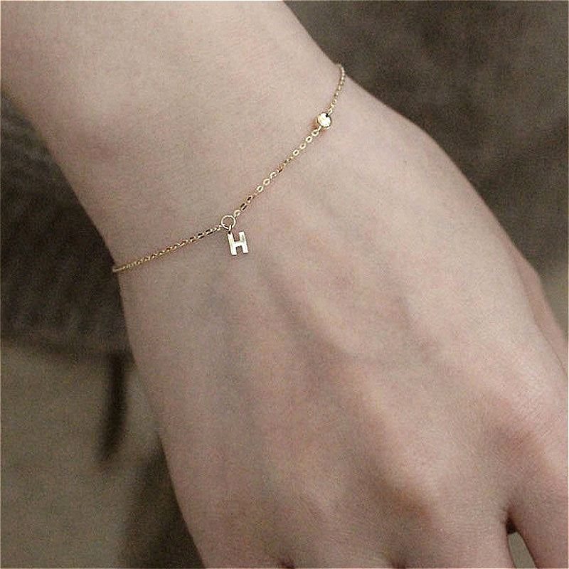  The 925 Silver-Plated K Gold H Letter Pendant Bracelet worn on a wrist, illustrating its elegant style and perfect fit for any occasion.
