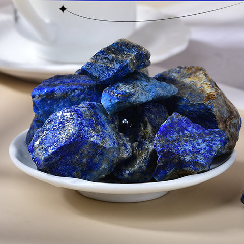  A close-up of a natural rough lapis lazuli stone, showcasing its rich deep blue color and distinctive golden pyrite flecks, emphasizing its raw beauty and unique texture.