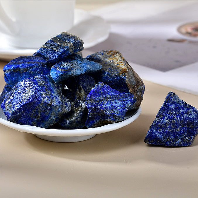 A side profile of a natural rough lapis lazuli stone, highlighting its irregular shape and the contrast between the vibrant blue surface and the rough edges, demonstrating its natural form.