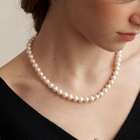 Model wearing a handmade natural freshwater pearl necklace, demonstrating its graceful fit and style