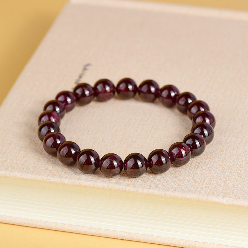 Side view of a natural garnet bead bracelet, highlighting the bead arrangement and elastic band, illustrating its comfortable fit.
