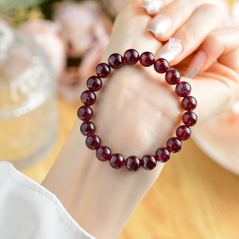  Natural garnet bead bracelet worn on a wrist, demonstrating its elegant look and spiritual significance as a piece of jewelry.