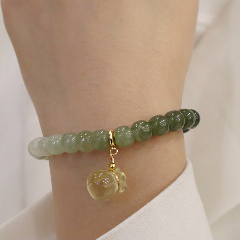  Model wearing the Natural Hetian Jade Gradient Bracelet with Lemon Quartz Money Bag Charm, showcasing its elegant fit and natural beauty.