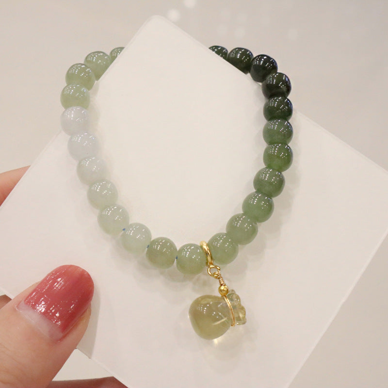 Natural Hetian Jade Gradient Bracelet with Lemon Quartz Money Bag Charm supported on a whiteboard, highlighting the colors and charm in a minimalist setting.